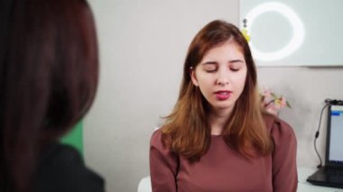 Kirpik uzatma ustasının işi. Lash Maker 'ın randevusundaki genç bir kız ve usta kirpikleri için farklı seçenekler sunuyor. 4k