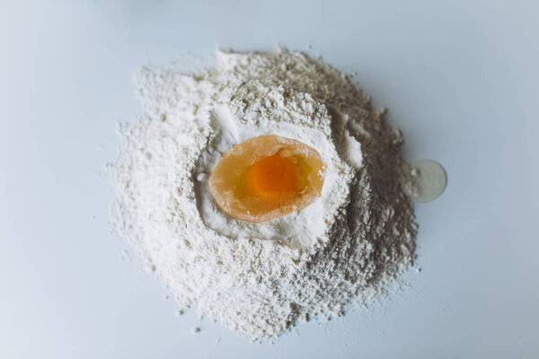 Egg in Flour on a White Table