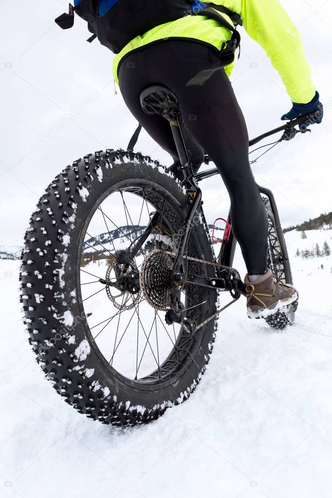 mountain bike with fat tires on snow covered trail in winter
