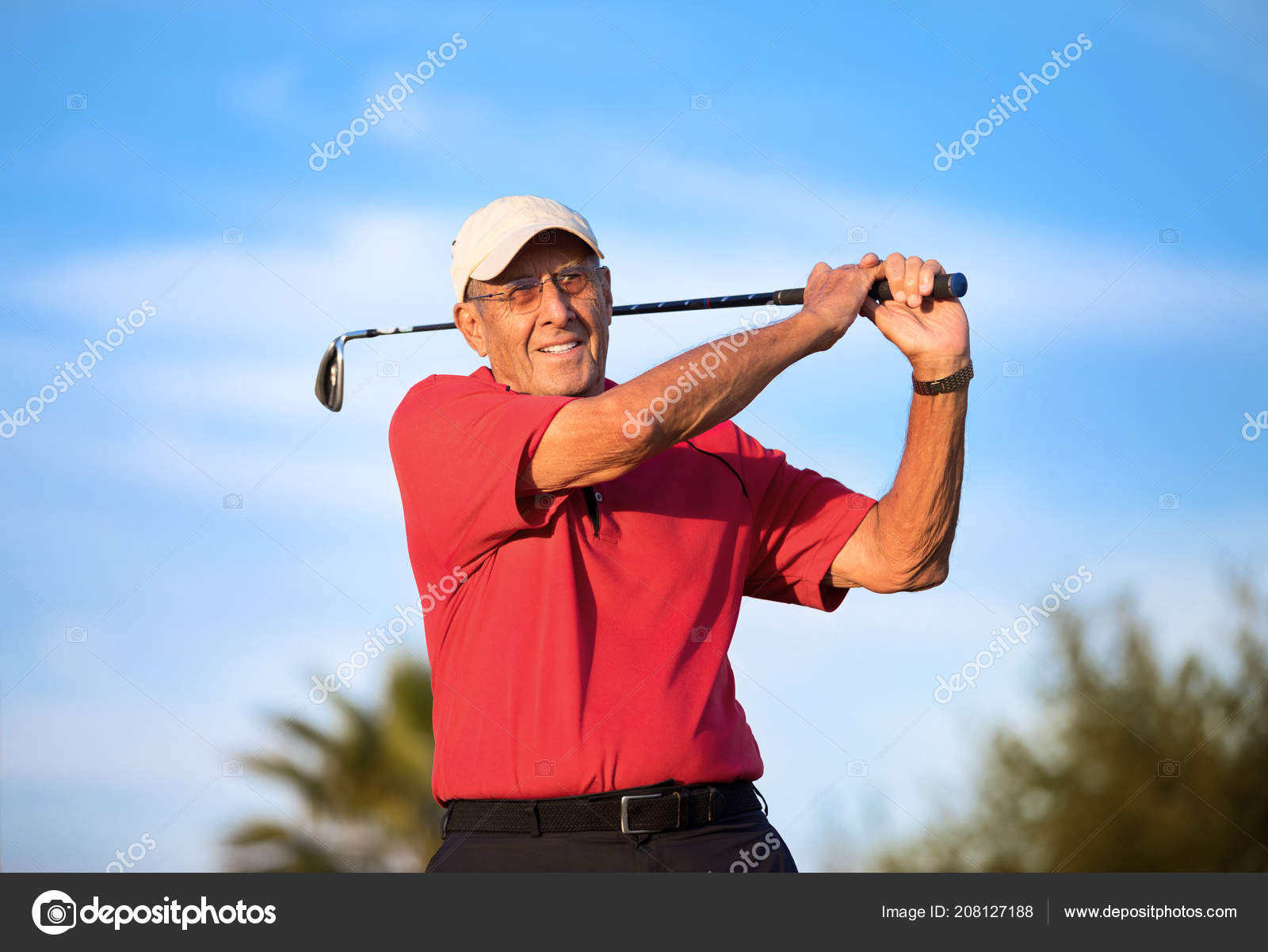 Active Senior Man Swinging Iron Golf Club Stock Photo