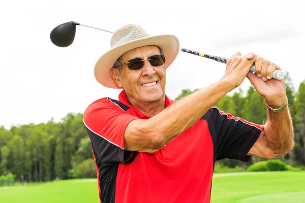 happy senior man swinging driver golf club.