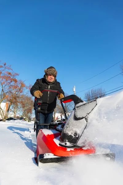 Senior man bort snö med snöslunga — Stockfoto