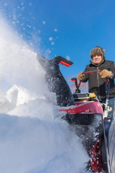 Senior beseitigt Schnee mit Schneefräse — Stockfoto