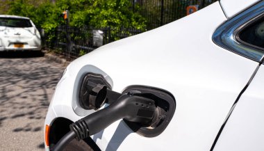 Şarj istasyonuna bağlı beyaz elektrikli araba