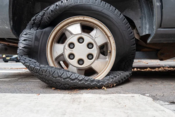 Automobile Flat tire from a blowout and the driver continued to drive on the bad tire. totally destroying the tire. — Stock Image Automobile Flat Tire Blowout Driver Continued Drive Bad Tire Totally Stock Photo