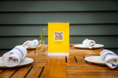 Coronavirüs salgını sırasında akıllı telefonun menüsünü güvenli bir şekilde görebilmesi için restoran QR kodu. QR kodu sahte ve post prodüksiyon için hazırlanmış.