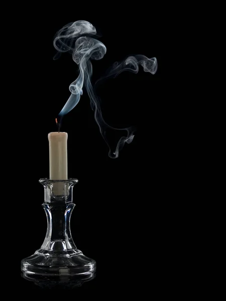 Smoke from the extinguished candle in a glass candlestick it is isolated on the black