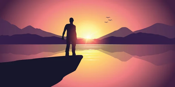 Uomo su una scogliera a paesaggio di montagna viola vicino al lago al tramonto — Vettoriale Stock