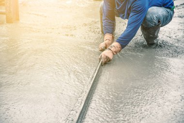 Oturma ve tahta bir spatula çimento için boşalırcasına hazır beton çelik takviye üzerinde sonra yolun karıştırılarak Mobil Beton Mikser yapmak kullanarak çalışan adam.