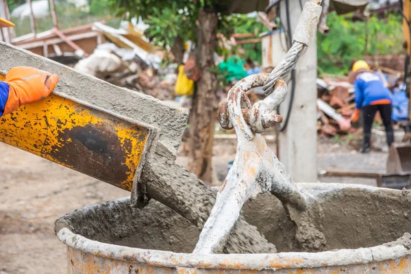 Pouring ready-mixed concrete from mixing mobile the concrete mixer into basket steel to lift the concrete to the point of inaccessibility.