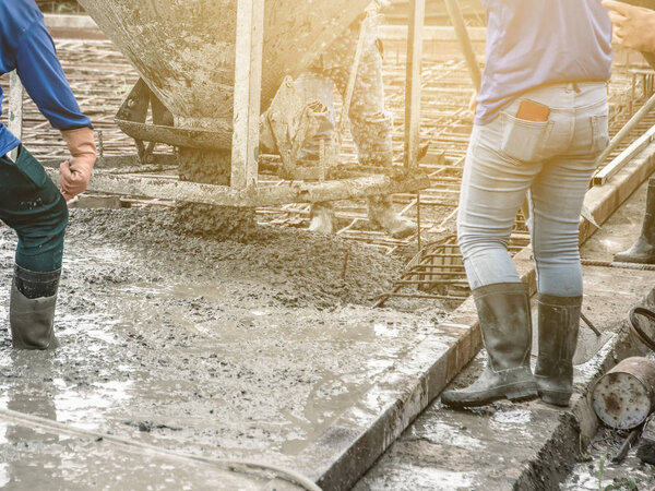 Pouring ready-mixed concrete from mixing mobile the concrete mixer into basket steel to lift the concrete to the point of inaccessibility.