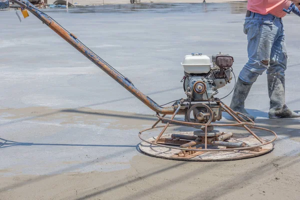 Workers are using concrete polishing machines for cement after Pouring ready-mixed concrete on steel reinforcement to make the road by mixing mobile the concrete mixer.