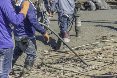 Beton kabarcıkları ortadan kaldırmak için bir titreşim makinesi kullanan işçi adam. çelik takviye karıştırma karayoluyla Mobil Beton Mikser yapmak için hazır beton dökme sonra.