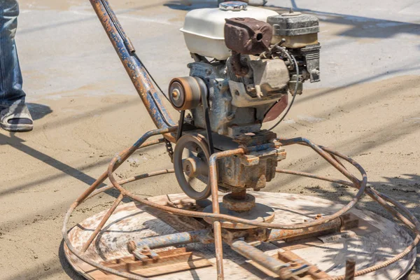 Workers are using concrete polishing machines for cement after Pouring ready-mixed concrete on steel reinforcement to make the road by mixing mobile the concrete mixer.