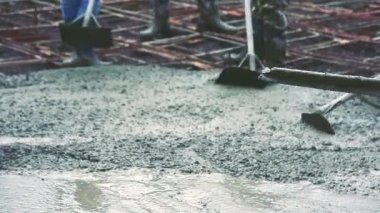 Adam Beton Mikser mobil karıştırma tarafından yol yapmak için çelik takviye hazır beton dökme sonra çimento için ahşap bir spatula kullanarak.