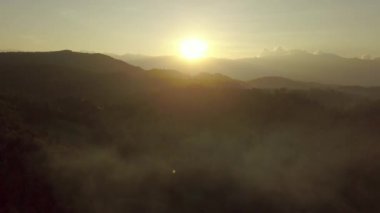 Hava manzarası, dağların ve ormanın üzerinde uçmak, gün doğumunda güzel bulutlar ve gökyüzü, hava kameralı kuş bakışı manzara.