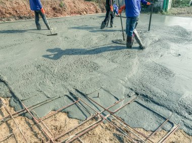 İşçiler üzerinde sonra boşalırcasına Hazır Beton Çimento için tahta bir spatula kullanarak yolun karıştırılarak Mobil Beton Mikser yapmak için takviye çelik.
