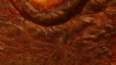 Bakır, demir ve pas renginde sıvı. Sudaki parlak pigmentler dalgalarda titreşir. Soyut bronz rengini nehrin rengine boyardı. Makro görüntüyü kapat. Mürekkep suyun altında dönüyor..