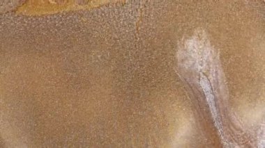 Bakır ve altından oluşan soyut bir alaşım. 