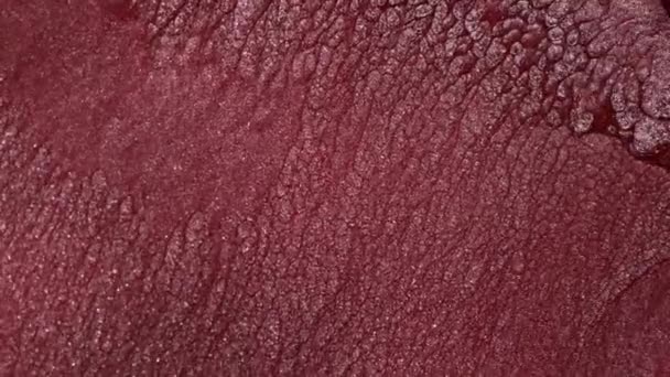 Un jet de peinture liquide rose et rouge avec des particules d'argent scintille. — Video