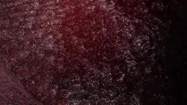 Un jet de peinture liquide rose et rouge avec des particules d'argent scintille. — Video