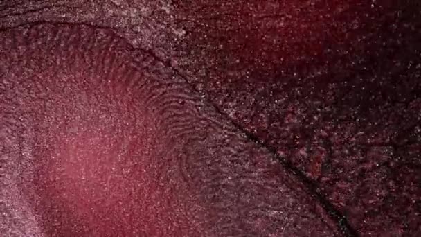 Um fluxo de tinta líquida rosa e vermelha com partículas de faíscas de prata . — Vídeo de Stock
