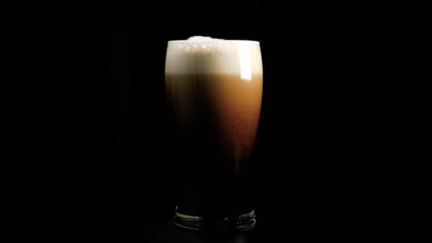 Una Pinta Espuma Cerveza Oscura Maravillosamente Sobre Fondo Negro — Vídeo de stock