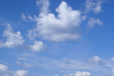 Gökyüzünde beyaz kabarık bulutlar. Hava güzel, hava açık ve güneşli. Gökyüzü mavi. Bulutlar yoğundur. Bazı bulutlar çoktan rüzgarı dağıttı ve inceldiler..