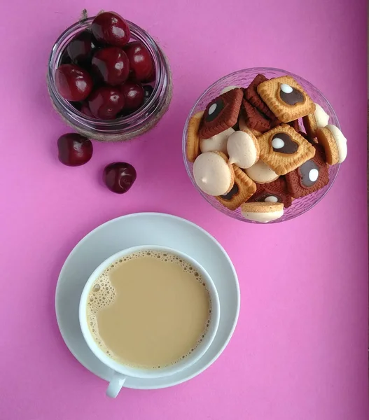 coffee berry cookies. having a snack. dessert. coffee with milk. pink background.