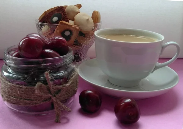 coffee berry cookies. having a snack. dessert. coffee with milk. pink background.