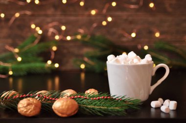 Hatmi, Ladin şube ve arka plan, seçici focus.bluer Noel ışıkları ile klasik bir ahşap yüzey üzerinde altın fındık ile kakao fincan