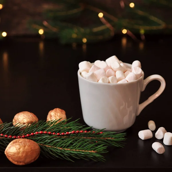 Hatmi, Ladin şube ve arka plan, seçici focus.bluer Noel ışıkları ile klasik bir ahşap yüzey üzerinde altın fındık ile kakao fincan