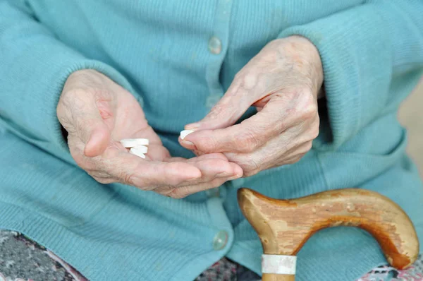 一个在街上拿着药丸的老妇人 90年了健康 关门了概念病症和医疗保健 — 图库照片