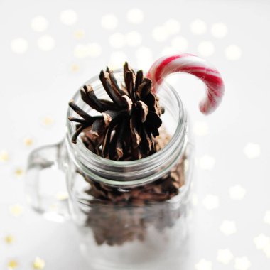 Parlayan yıldızlar ve koniler bir cam kavanoz ve karamel ile sihirli Noel kartı. üstten görünüm. kare