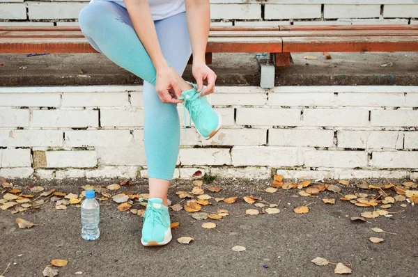 A girl with excess weight is going to go in for sports to lose weight and the water bottle at the stadium. Healthy lifestyle.