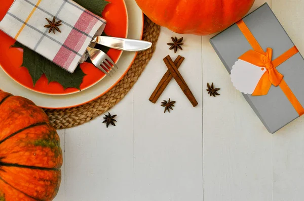Beautiful dining table setting for thanksgiving theme and beautiful fall card in white and orange colors.
