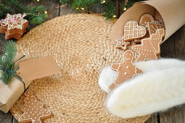 Grappige speculaaspop op wit gebreide wanten op een mooie houten achtergrond. Kerstboom die versierd met lichten. — Stockfoto