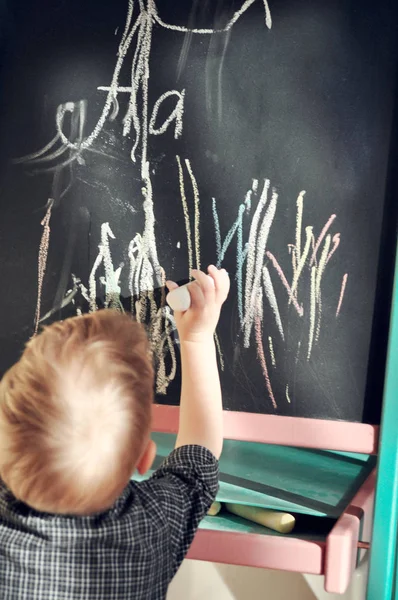 Černá křída deska načmáral něco boy barevné pastelky. Učení abecedy a příprava na školu — Stock fotografie