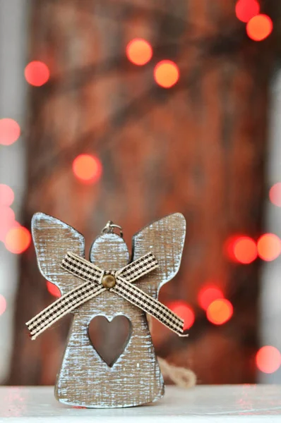 Schattig houten engel decoratie op de kerstboom op de achtergrond van rode lichten op straat — Stockfoto