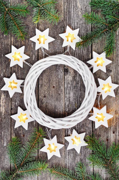 魔法のクリスマス境界線 居心地の良い温かみのあるライト ガーランド星と素朴な木製の背景に白い花輪を捧げる周りのモミの枝 平面図です 上の手 コピー スペース — ストック写真