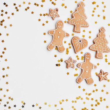 Tatil parlak arka plan. Geleneksel ev yapımı gingerbread çerezleri beyaz zemin üzerinde bir komik küçük adam, yıldız, kalp, ağaç, Altın Koza şeklinde buzlanma şeker. Noel süsler.