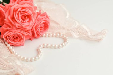 Narin kadınsı tema. Pembe mercan gül rengi soluk pembe sutyen ve beyaz zemin üzerine inci kolye trend. üstten görünüm. yakın çekim. Şık iç çamaşırı düz yatıyordu. İç çamaşırı moda kavramı