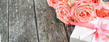 Hassas mercan pembe gül ve hediye rustik ahşap zemin üzerine gölge. Sevgiliye arka plan. Tatil kartı kadınlar için