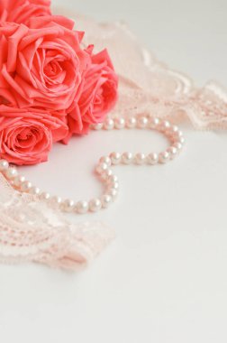 Narin kadınsı tema. Pembe mercan gül rengi soluk pembe sutyen ve beyaz zemin üzerine inci kolye trend. üstten görünüm. yakın çekim. Şık iç çamaşırı düz yatıyordu. İç çamaşırı moda kavramı.