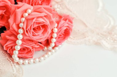 Narin kadınsı tema. Pembe mercan gül rengi soluk pembe sutyen ve beyaz zemin üzerine inci kolye trend. üstten görünüm. yakın çekim. Şık iç çamaşırı düz yatıyordu. İç çamaşırı moda kavramı.