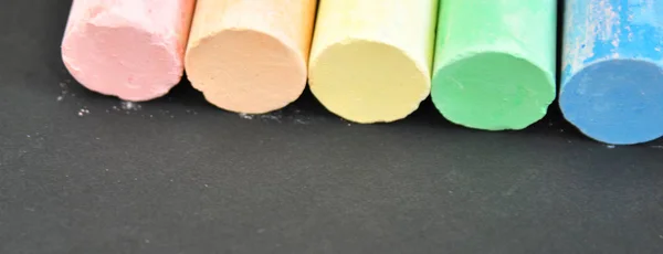 Koyu bir arka plan yakın çekim okul renkli boya kalemleri. Eğitim ve öğretim kavramsaldır. Renk tebeşir — Stok fotoğraf