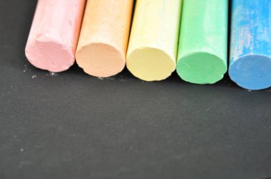 Koyu bir arka plan yakın çekim okul renkli boya kalemleri. Eğitim ve öğretim kavramsaldır. Renk tebeşir