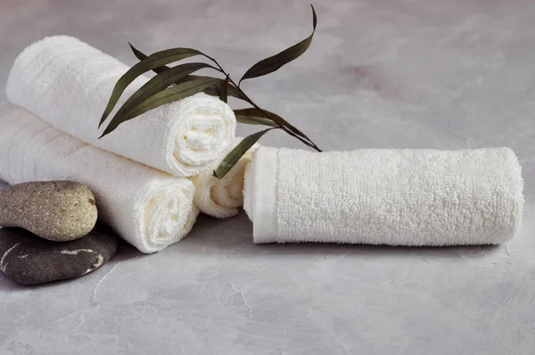 Zamknij widok Spa relaks koncepcja. Ręczniki frotte biały, kamienie i gałęzi na szary teksturowanej tło. — Zdjęcie stockowe