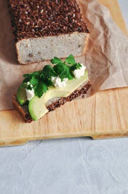 Sağlıklı ve uygun kahvaltı. Maya ile keten tohumu, ayçiçeği yeşil buğday ve avokado ve ev yapımı ekmek ile sandviç. RAW ve vegan gıda.