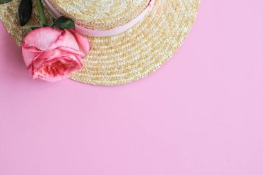 Yaz hasır şapka ile narin pejmürde kart, pembe şakayık pembe arka planda yükseldi. yakın çekim.